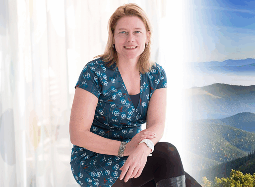 Vrouw in blauwe jurk met berglandschap op achtergrond